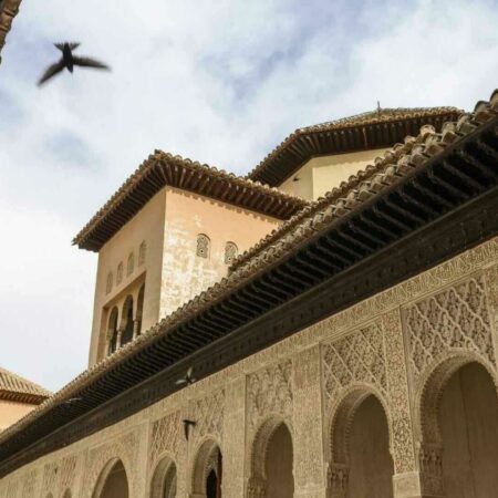 Vista exterior de la Alhambra en Granada, destacando su arquitectura detallada y un cielo despejado, ideal para una visita a Alhambra. Todo ello podrás experimentarlo en nuestra Visita Guiada Alhambra y Palacios Nazaríes más Leyendas