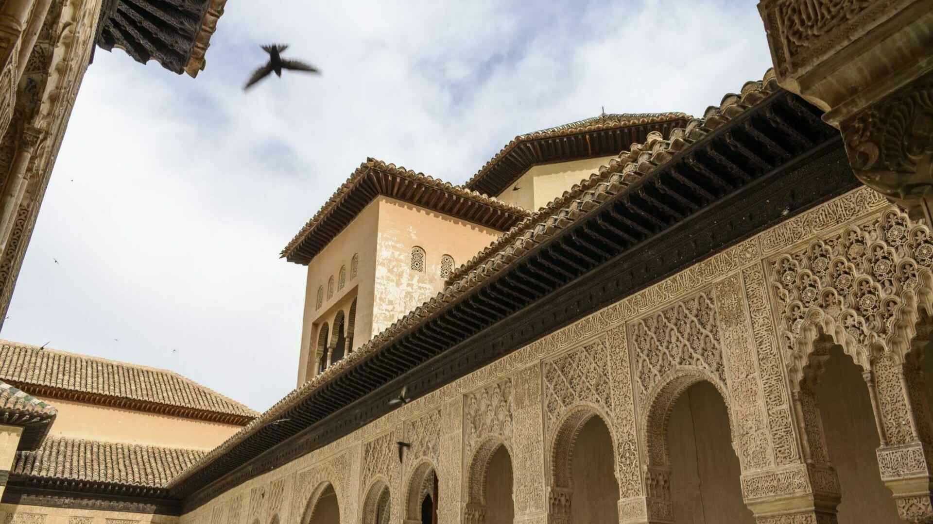 Vista exterior de la Alhambra en Granada, destacando su arquitectura detallada y un cielo despejado, ideal para una visita a Alhambra. Todo ello podrás experimentarlo en nuestra Visita Guiada Alhambra y Palacios Nazaríes más Leyendas